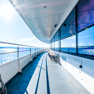 Deck of a boat, ocean reflected in the boat window